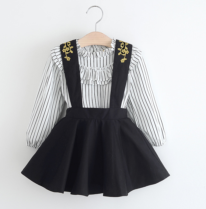 ruffled striped long sleeve shirt with black halter dress. Gold stitching lines the front and back of the straps. 