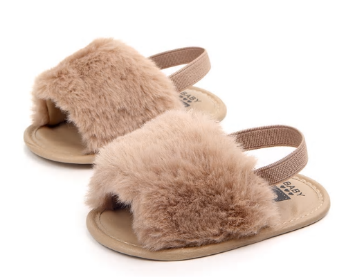 These adorable slippers come in 4 colors (beige, black, grey and pink) and have an elastic strap in the back to secure the slipper. The front of the slipper has a puff of faux fur to cover those little toes. We love this addition to our shoe collection!