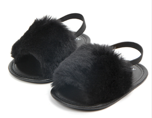 These adorable slippers come in 4 colors (beige, black, grey and pink) and have an elastic strap in the back to secure the slipper. The front of the slipper has a puff of faux fur to cover those little toes. We love this addition to our shoe collection!