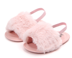 These adorable slippers come in 4 colors (beige, black, grey and pink) and have an elastic strap in the back to secure the slipper. The front of the slipper has a puff of faux fur to cover those little toes. We love this addition to our shoe collection!