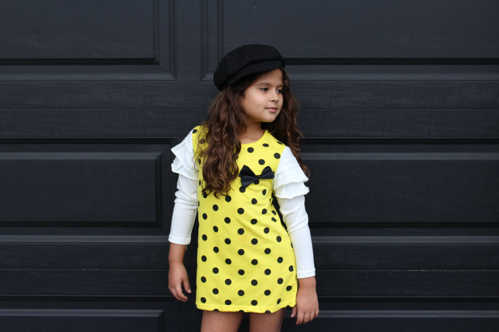 This fun polka dot dress is the perfect piece for a party! We have two vibrant colors in stock -Pink and Yellow. Both colors have long sleeves attached with ruffles on the shoulders. A bow sits on the left chest.