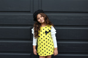 This fun polka dot dress is the perfect piece for a party! We have two vibrant colors in stock -Pink and Yellow. Both colors have long sleeves attached with ruffles on the shoulders. A bow sits on the left chest.