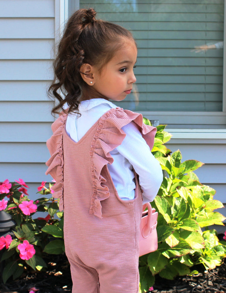 The Ruffle Pink Romper is for the Boho Chic diva girls. This V neck romper is pale pink with ruffles lining the front. Snaps are located at the bottom of the romper for easy diaper changes.