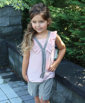 checkered shorts lined with two buttons on each side and flutter sleeveless pink top with extra sting to tie in a bow. 