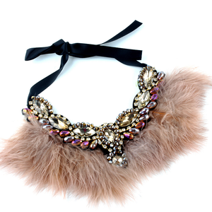 Calling all Boujie Diva's! Our crystal feather necklaces are the perfect addition for our mini diva's all the way up to our mama diva's. Each necklace sits high on top of your existing shirt and is lined with colorful feathers and shining crystals.  Mix and match with your mini for the perfect stylish accessory!  Available in beige, black, red and blue